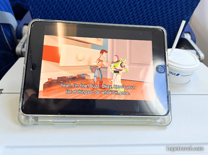 機内でダウンロードしたディズニープラスの映画「トイストーリー」を見る様子